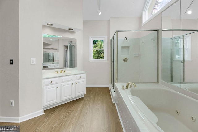 1197 Kenilworth Trce, Snellville, GA 30078 - bathroom featuring a tub with jets, vanity, wood finished floors, and a shower stall