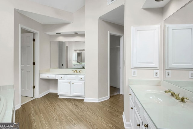 1197 Kenilworth Trce, Snellville, GA 30078 - full bathroom with wood finished floors, two vanities, a tub to relax in, and a closet