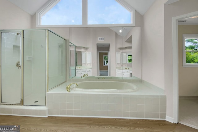 1197 Kenilworth Trce, Snellville, GA 30078 - bathroom with vaulted ceiling, a stall shower, a garden tub, wood finished floors, and vanity