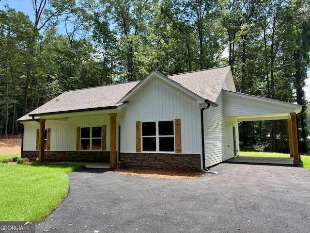 TRACT3 Grogan Rd, Buchanan, GA 30113 - view of front facade featuring driveway, stone siding, roof with shingles, a front yard, and a carport
