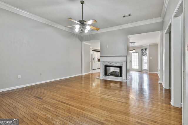 77 Springfield Ct, Newnan, GA 30265 - unfurnished living room with ornamental molding, light wood-style flooring, ceiling fan, and a premium fireplace