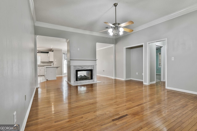 77 Springfield Ct, Newnan, GA 30265 - unfurnished living room with ceiling fan, crown molding, light wood finished floors, and a high end fireplace
