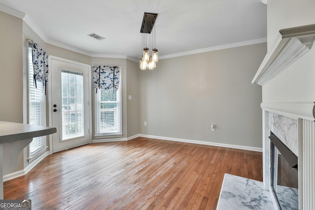 77 Springfield Ct, Newnan, GA 30265 - unfurnished living room featuring light wood-type flooring, crown molding, a premium fireplace, and a chandelier