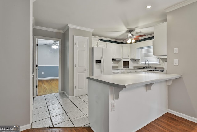 77 Springfield Ct, Newnan, GA 30265 - kitchen with white refrigerator with ice dispenser, ceiling fan, a peninsula, white cabinetry, and recessed lighting