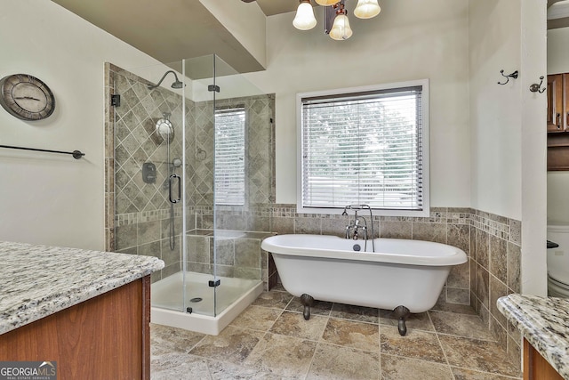 77 Springfield Ct, Newnan, GA 30265 - bathroom featuring tile walls, a freestanding tub, a shower stall, a chandelier, and vanity