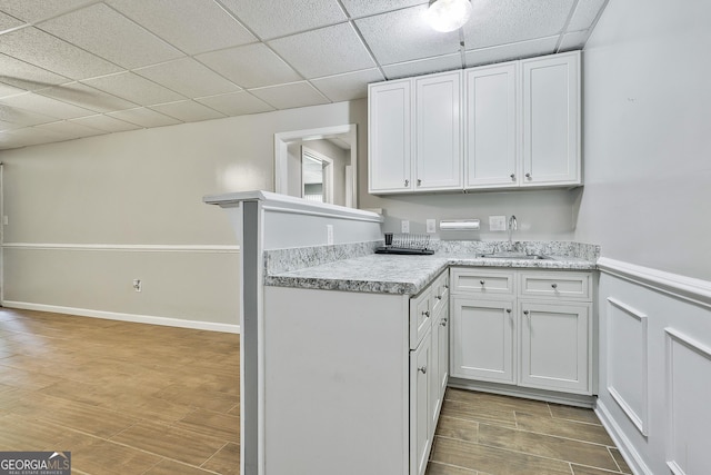 77 Springfield Ct, Newnan, GA 30265 - kitchen with light countertops, wood finished floors, a paneled ceiling, and white cabinetry