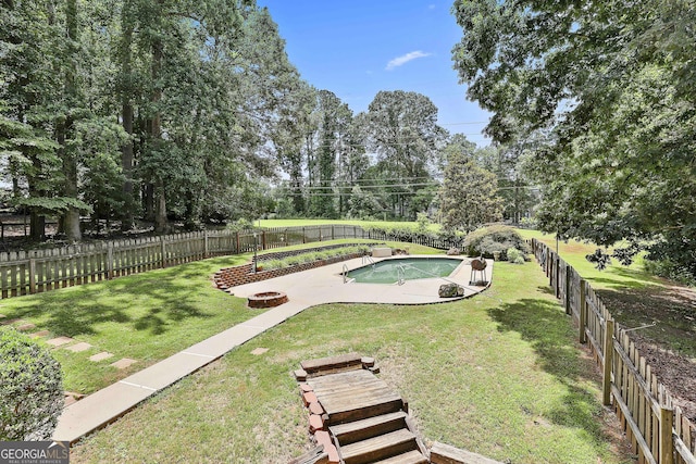 77 Springfield Ct, Newnan, GA 30265 - fenced backyard featuring an outdoor fire pit and view of wooded area