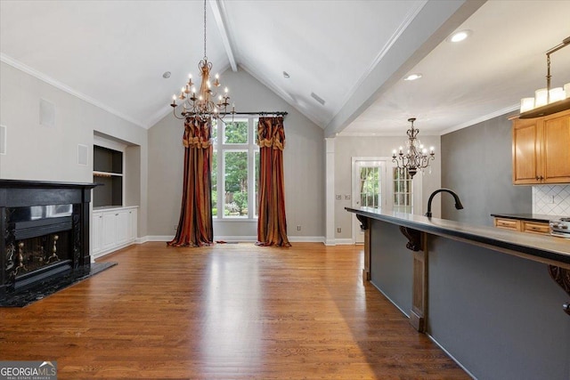 133 N Wellington, Macon, GA 31210 - kitchen featuring a chandelier, wood finished floors, a fireplace, decorative light fixtures, and decorative backsplash
