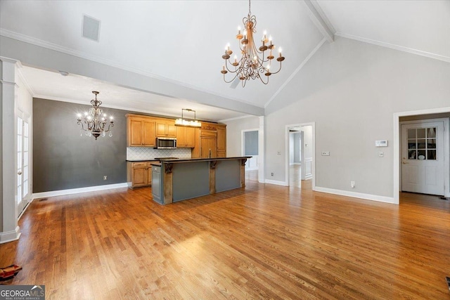 133 N Wellington, Macon, GA 31210 - kitchen with a chandelier, dark countertops, stainless steel microwave, beamed ceiling, and a breakfast bar area