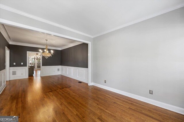 133 N Wellington, Macon, GA 31210 - unfurnished room with a chandelier, dark wood-style flooring, a wainscoted wall, a decorative wall, and ornamental molding