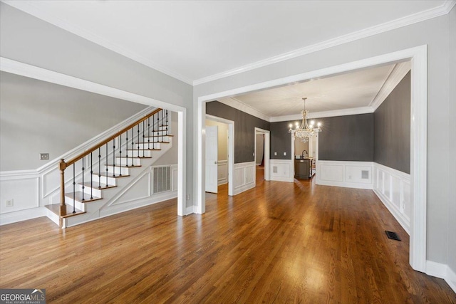 133 N Wellington, Macon, GA 31210 - unfurnished dining area featuring a chandelier, stairway, a decorative wall, dark wood-type flooring, and a wainscoted wall