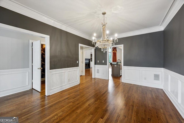 133 N Wellington, Macon, GA 31210 - unfurnished dining area featuring a chandelier, dark wood finished floors, wainscoting, ornamental molding, and a decorative wall