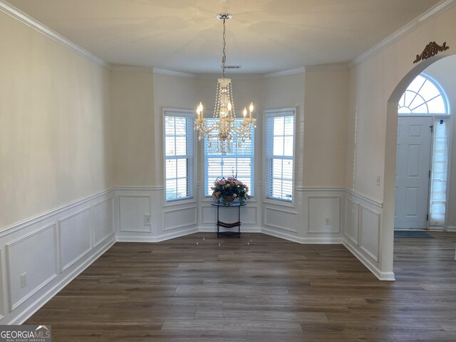 1238 Polk Xing, Mcdonough, GA 30252 - unfurnished dining area with arched walkways, a chandelier, wainscoting, dark wood-style floors, and ornamental molding