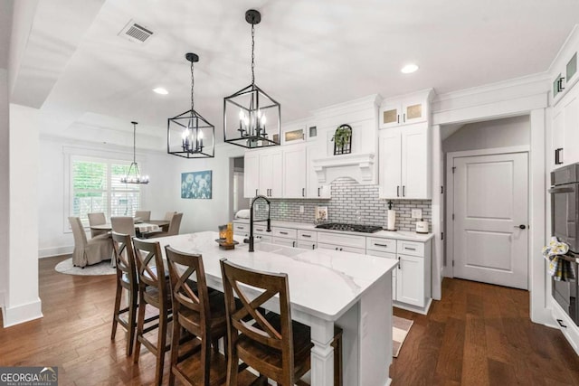 213 River Trl, Ball Ground, GA 30107 - kitchen featuring a chandelier, a center island with sink, tasteful backsplash, a breakfast bar, and hanging light fixtures