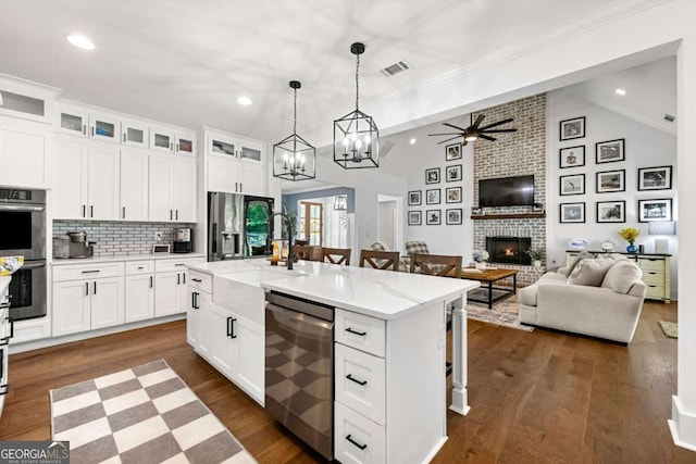 213 River Trl, Ball Ground, GA 30107 - kitchen featuring stainless steel appliances, open floor plan, vaulted ceiling, recessed lighting, and a kitchen bar