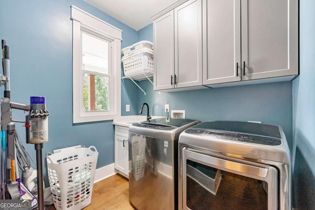 213 River Trl, Ball Ground, GA 30107 - washroom featuring washing machine and clothes dryer, cabinet space, and light wood-type flooring