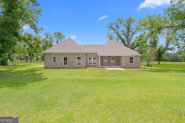 19 Honeysuckle Dr, Claxton, GA 30417 - rear view of property featuring a patio area, a lawn, brick siding, and roof with shingles