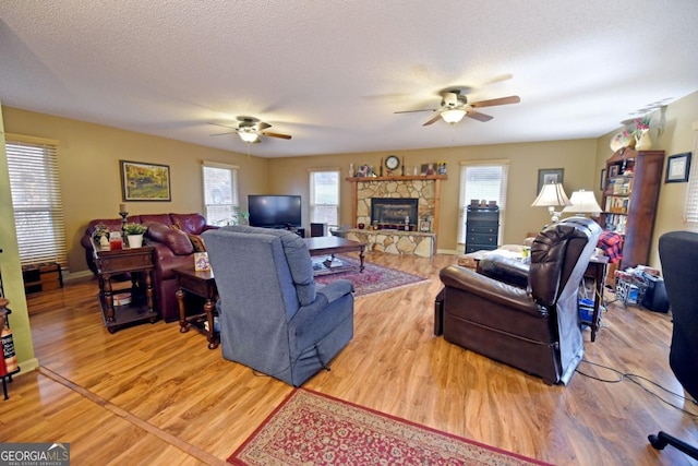 104 Bowers Cir, Blairsville, GA 30512 - living area featuring a ceiling fan, wood finished floors, and a stone fireplace