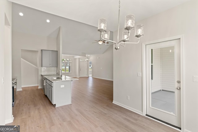 109 Wave Break Ct, Kingsland, GA 31548 - kitchen featuring a chandelier, gray cabinetry, open floor plan, a kitchen island with sink, and light stone countertops