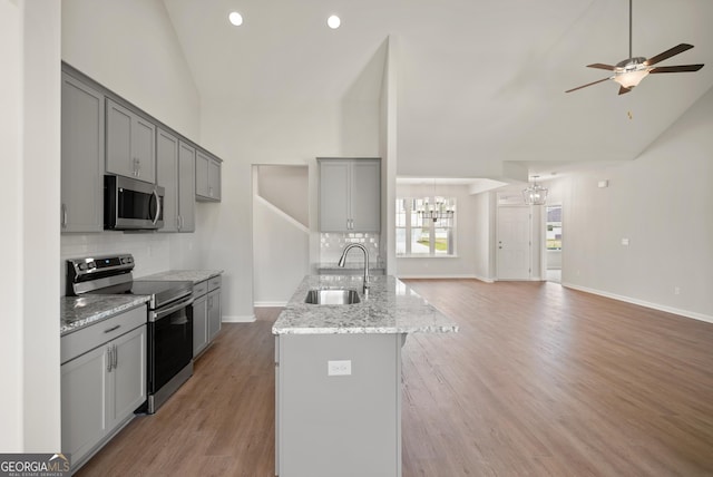 109 Wave Break Ct, Kingsland, GA 31548 - kitchen featuring appliances with stainless steel finishes, a chandelier, gray cabinets, backsplash, and open floor plan