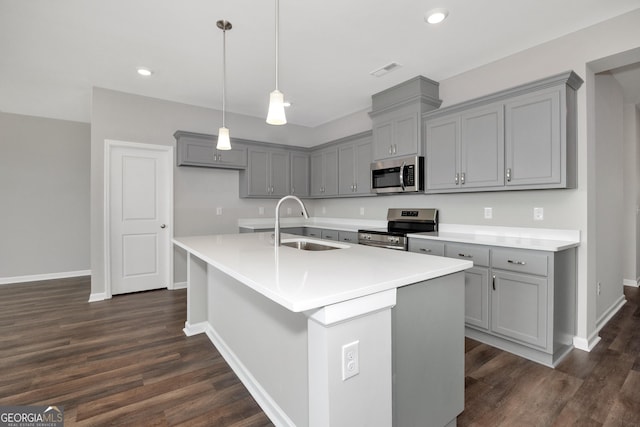 103 Gnome Ct, Perry, GA 31069 - kitchen featuring appliances with stainless steel finishes, gray cabinets, dark wood-style flooring, recessed lighting, and a center island with sink