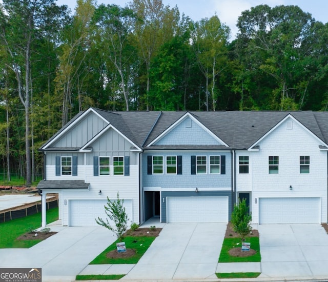42 Buckingham Ln Unit 233, Hoschton, GA 30548 - view of property with board and batten siding, an attached garage, driveway, and roof with shingles