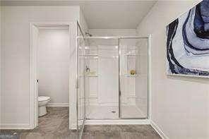 42 Buckingham Ln Unit 233, Hoschton, GA 30548 - full bathroom featuring toilet and a shower stall