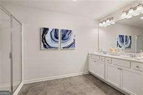 42 Buckingham Ln Unit 233, Hoschton, GA 30548 - full bathroom with double vanity and an enclosed shower