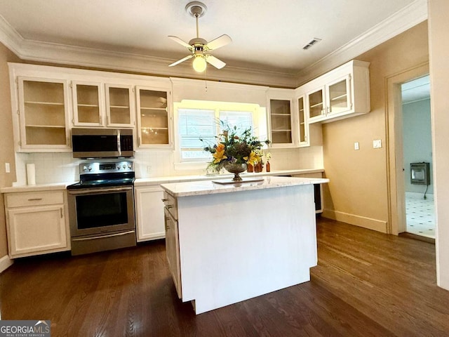 516 Longview St, Carrollton, GA 30117 - kitchen with stainless steel appliances, ornamental molding, dark wood-type flooring, ceiling fan, and white cabinets