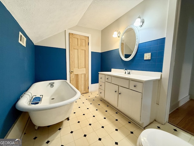 516 Longview St, Carrollton, GA 30117 - full bath featuring tile walls, a freestanding bath, a textured ceiling, vanity, and lofted ceiling