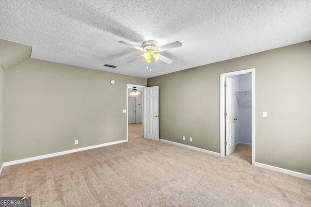 116 Overlook Bnd, Kingsland, GA 31548 - unfurnished bedroom featuring light colored carpet, a spacious closet, a ceiling fan, a textured ceiling, and a closet