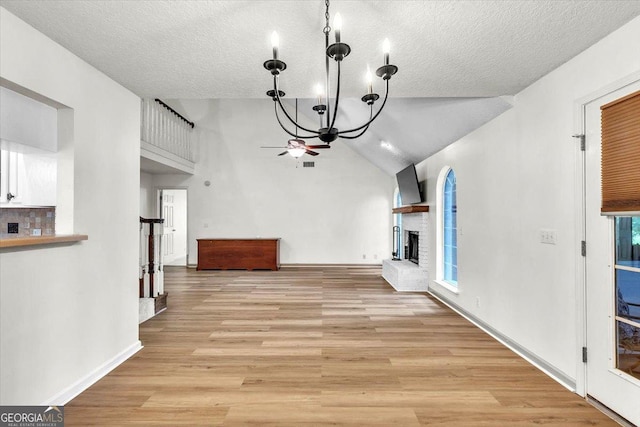 116 Overlook Bnd, Kingsland, GA 31548 - unfurnished living room featuring ceiling fan, a fireplace, light wood finished floors, a textured ceiling, and high vaulted ceiling