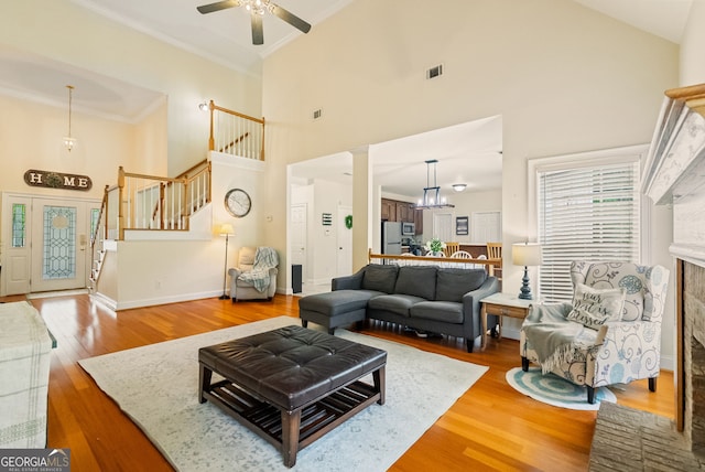 595 Mcgarity Dr, Mcdonough, GA 30252 - living area with a high ceiling, stairway, a ceiling fan, ornamental molding, and wood finished floors