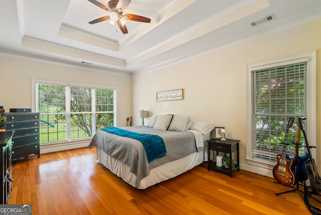 595 Mcgarity Dr, Mcdonough, GA 30252 - bedroom featuring crown molding, a raised ceiling, wood finished floors, and a ceiling fan