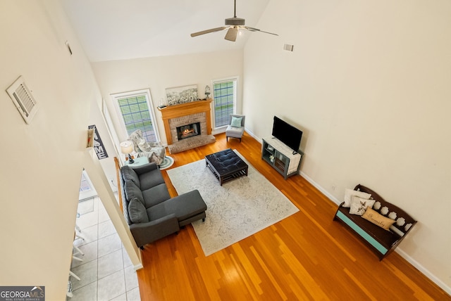 595 Mcgarity Dr, Mcdonough, GA 30252 - living room with wood finished floors, high vaulted ceiling, a ceiling fan, and a glass covered fireplace