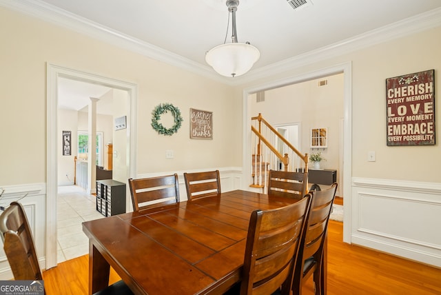 595 Mcgarity Dr, Mcdonough, GA 30252 - dining room with crown molding, wainscoting, stairway, and light wood-style flooring