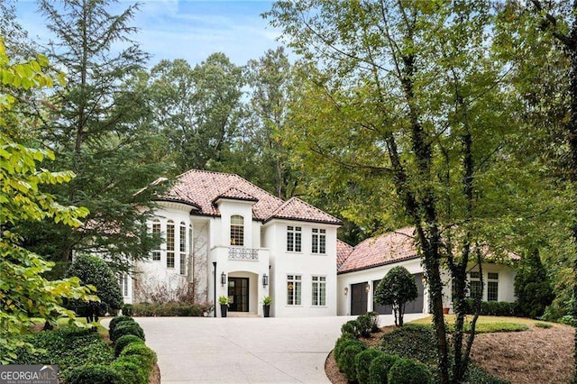 3401 Stillhouse Rd SE, Atlanta, GA 30339 - mediterranean / spanish home with an attached garage, concrete driveway, stucco siding, and a tile roof