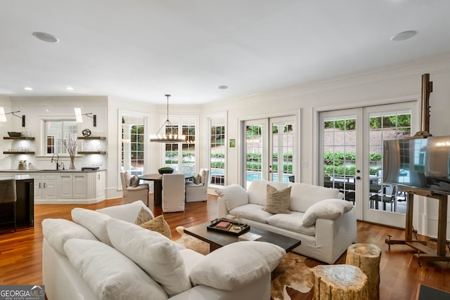 3401 Stillhouse Rd SE, Atlanta, GA 30339 - living room featuring a chandelier, french doors, light wood-style floors, and ornamental molding