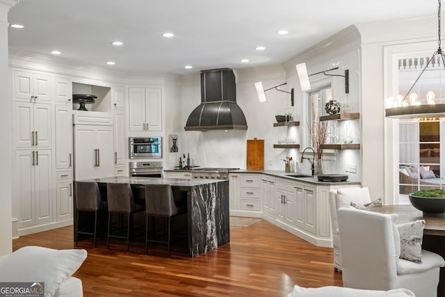 3401 Stillhouse Rd SE, Atlanta, GA 30339 - kitchen with open shelves, premium range hood, oven, wood finished floors, and crown molding