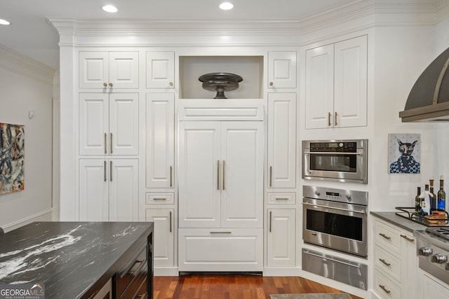 3401 Stillhouse Rd SE, Atlanta, GA 30339 - kitchen featuring appliances with stainless steel finishes, a warming drawer, exhaust hood, ornamental molding, and dark wood-style floors
