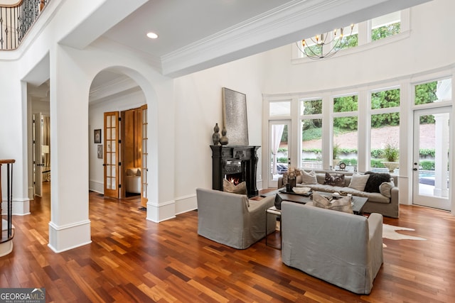 3401 Stillhouse Rd SE, Atlanta, GA 30339 - living room with arched walkways, ornamental molding, dark wood-style flooring, a towering ceiling, and healthy amount of natural light