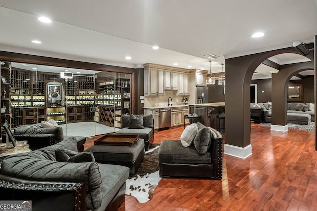 3401 Stillhouse Rd SE, Atlanta, GA 30339 - living room featuring ornamental molding, wood finished floors, arched walkways, recessed lighting, and bar with sink