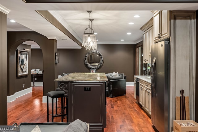 3401 Stillhouse Rd SE, Atlanta, GA 30339 - kitchen with appliances with stainless steel finishes, a center island, a breakfast bar area, dark wood-type flooring, and ornamental molding