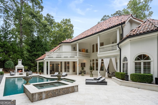 3401 Stillhouse Rd SE, Atlanta, GA 30339 - back of house featuring a warm lit fireplace, a patio area, a balcony, and stucco siding