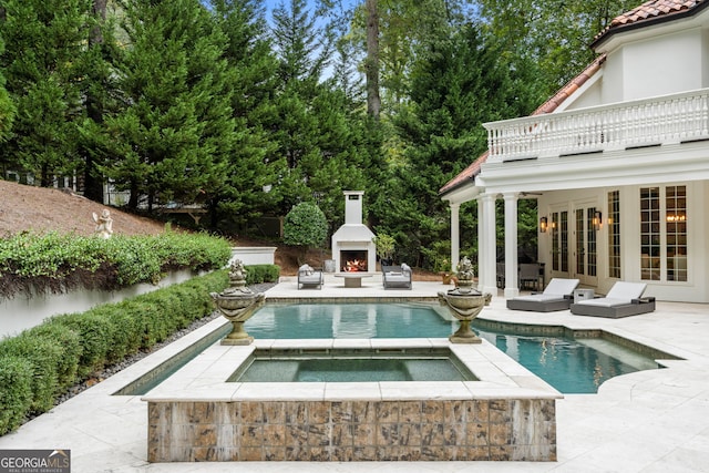 3401 Stillhouse Rd SE, Atlanta, GA 30339 - outdoor pool with a lit fireplace, a patio area, an in-ground hot tub, and french doors