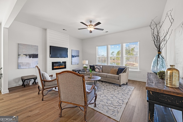 1313 Pj E Rd, Covington, GA 30014 - living area featuring a large fireplace, ceiling fan, and wood finished floors