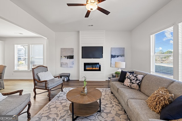 1313 Pj E Rd, Covington, GA 30014 - living room featuring healthy amount of natural light, a ceiling fan, wood finished floors, and a large fireplace