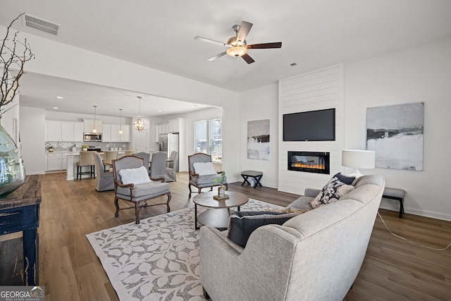 1313 Pj E Rd, Covington, GA 30014 - living room featuring a large fireplace, ceiling fan, and wood finished floors