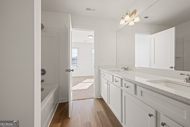 1313 Pj E Rd, Covington, GA 30014 - bathroom featuring double vanity, wood finished floors, and washtub / shower combination