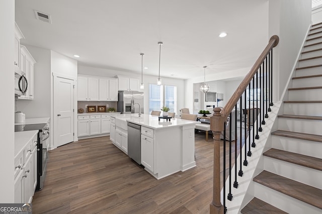 1313 Pj E Rd, Covington, GA 30014 - kitchen with stainless steel appliances, dark wood-style flooring, white cabinetry, recessed lighting, and light countertops